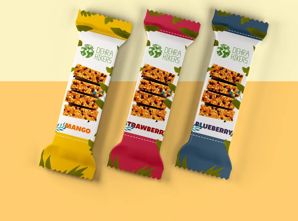 Three fruit-and-oat bars in yellow, crimson and navy wrappers labelled mango, strawberry and blueberry, all carrying the Dehra Hikers mark.